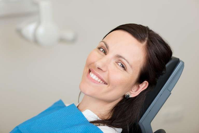 woman sitting in a dental chair | dental cleaning
