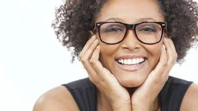 Smiling woman with curly hair and glasses